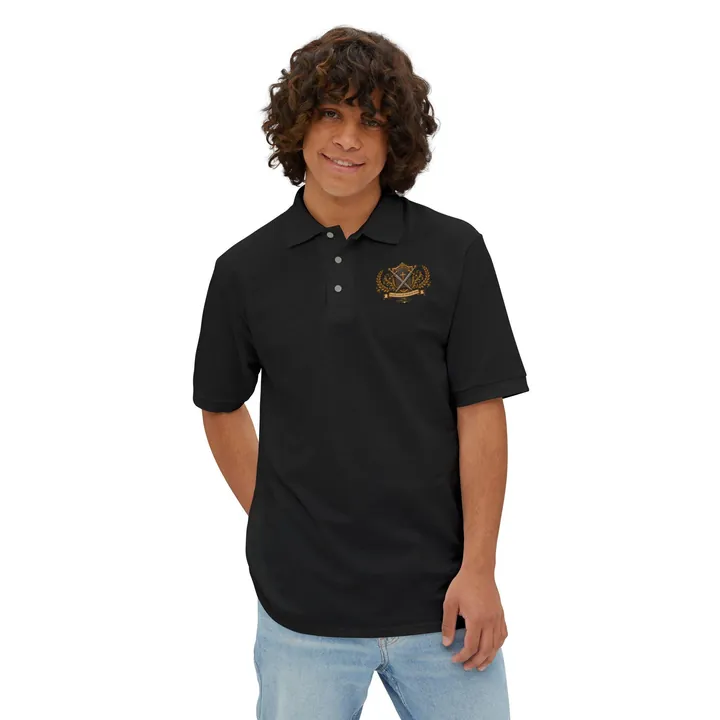 Man wearing a black piqué polo shirt with a small gold crest of a Bible, two crossed swords and laurels (Hebrews 4:12) on the left chest